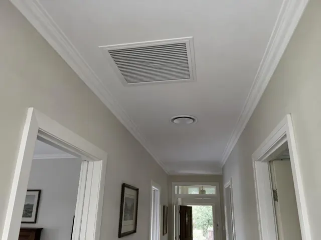 Ceiling return-air grille in a hallway with white trim and grey walls in Belair